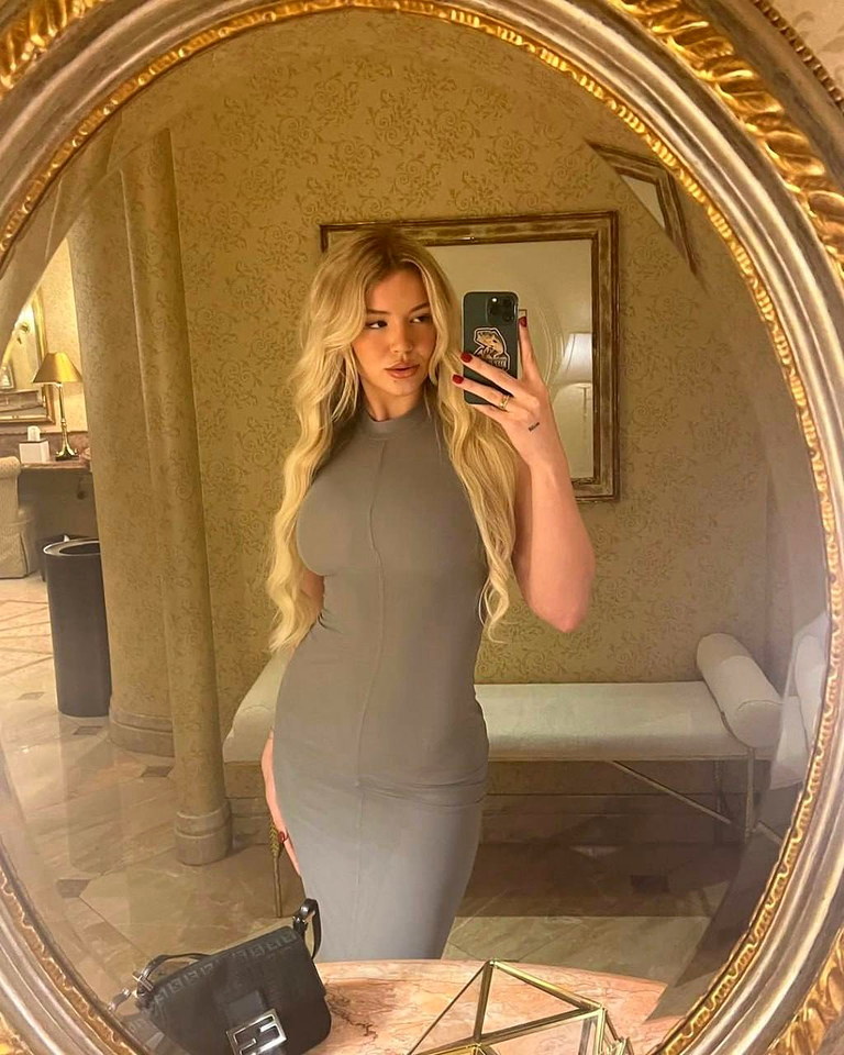 Tay LaVie taking a mirror photo in a gray dress
